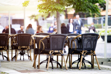 Reastaurant tables waiting for customers at an outdoor terrace.