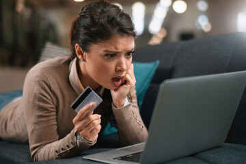 Young businesswoman at home makes a purchase on the Internet. Beautiiful woman on the laptop with credit card	
