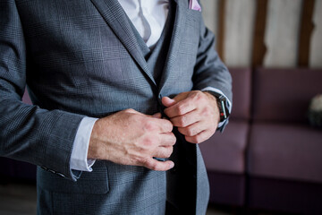 man fastens a button on a jacket