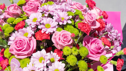 Colorful flower bouqet arrangement. Summer flowers held by florist in hand close up. Flowers for wedding and happy occasions.