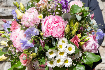 Colorful flower bouqet arrangement. Summer flowers held by florist in hand close up. Flowers for...