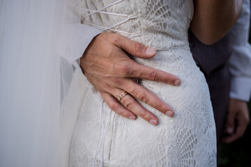 hand of the groom on waist of the bride