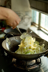 A chef is cooking cabbage