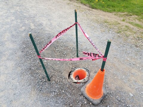 Hole With Orange Cones And Red Danger Tape