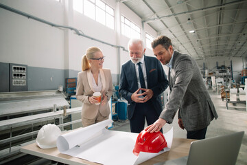 Fototapeta premium Colleagues working on project. Team of architects discussing business in factory.