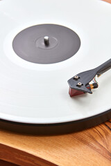 Vintage record player with vinil disc on a wooden table.