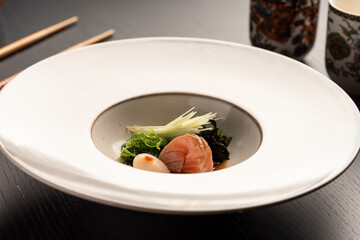 sashimi japanese dish with vegetables on white ceramic