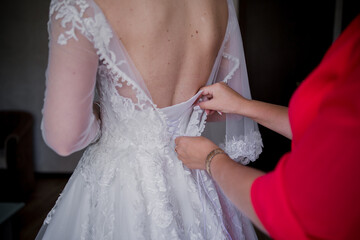 Fototapeta na wymiar bride puts on a wedding dress
