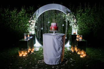 wedding cake near the arch in the evening