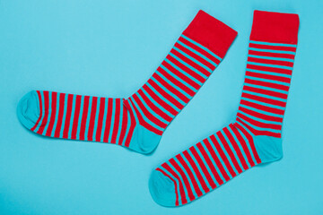 pair of striped socks laid out on a turquoise background, concept