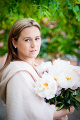 Portrait of a woman with peonies on the street