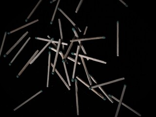matches are randomly scattered on the black table