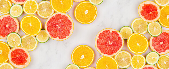 Creative background made of summer tropical fruits with grapefruit, orange, tangerine, lemon, lime on white marble background. Food concept. Flat lay, top view, copy space, mockup