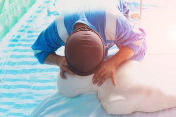 CPR Training medical procedure - Demonstrating chest compression on CPR Doll in class, First Aids Emergency CPR on heart attack doll