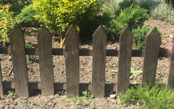 small fence of planks in the garden of the house in bright light
