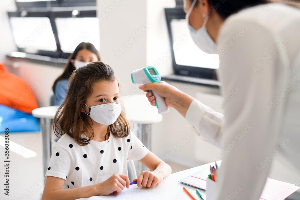 Wall mural Teacher, child with face mask at school after covid-19 quarantine and lockdown.