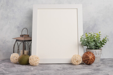 White empty frame on a light wall background with designer accessories, layout for advertising fonts, logos