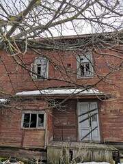 Fototapeta na wymiar dilapidated wooden house behind a tree