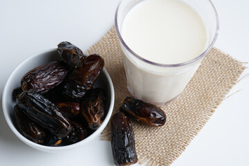 Dates milk and dates in the bowl on grey background.
