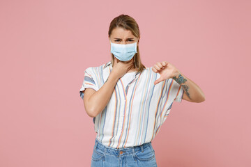 Sick young woman in striped shirt sterile face mask isolated on pink background. Epidemic pandemic...