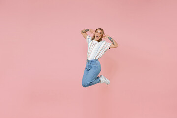 Cheerful young blonde woman girl in casual striped shirt posing isolated on pastel pink background...
