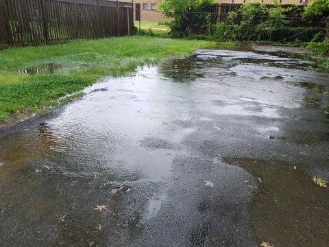 large water puddle from rain in driveway and grass