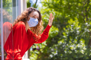 Woman in quarantine looking through the window