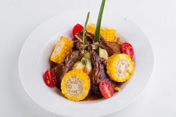 Mashed potatoes with corn, lamb thighs and tomato. Hot dish with meat