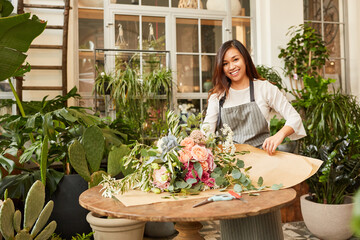 Young florist wraps big bunch of flowers