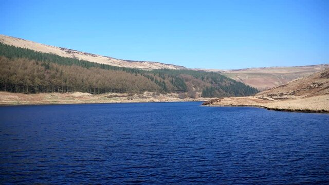 Yeoman Hey Reservoir in Peak District National Park, view from dam on a bright sunny day in spring.