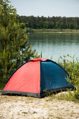 Tent for hiking by the lake in the woods.
