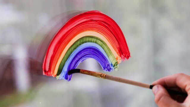 Painting rainbow on window. LGBT pride rainbow include of Lesbian, gay, bisexual, and transgender.