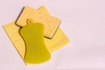 Yellow rags and sponges for washing dishes on a white background