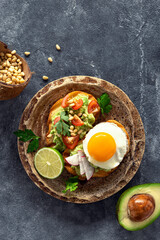 Obraz na płótnie Canvas Sandwiches for breakfast with avocado puree, fried egg and vegetables
