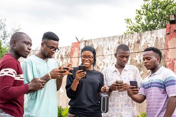 group of young africans using their phones, hanging out together, students leisure on campus