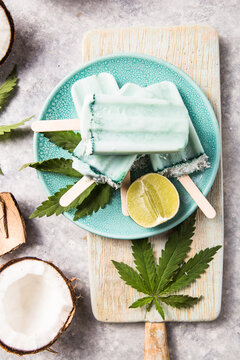 ice cream popsicle bars with coconut slices, cannabis or hemp  on concrete background.