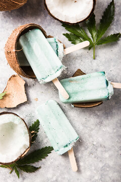 ice cream popsicle bars with coconut slices, cannabis or hemp  on concrete background.