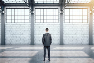 Businessman standing in contemporary warehouse interior