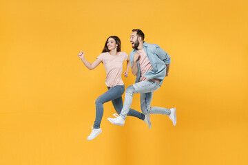 Excited young couple two friends guy girl in pastel blue casual clothes posing isolated on yellow...