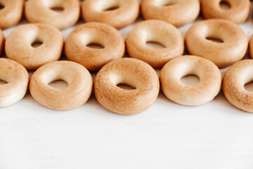 Drying or mini round bagels on a white wooden background. Copy, empty space for text