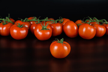 Rote Tomaten / Rispentomaten auf einem schwarzen Hintergrund