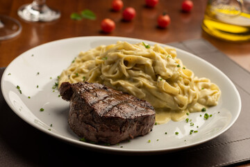 Fototapeta na wymiar steak with pasta tagliatelle fetuccini on plate with blurred background with tomatoes olive oil and wine glass