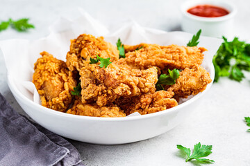 Crispy fried chicken in a white bowl.
