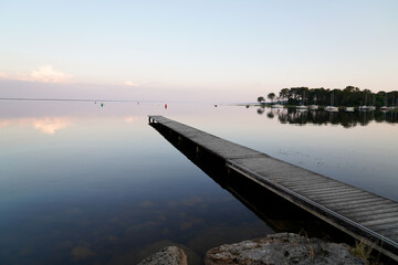 pier and sky reflection water on wood pontoon on lake of Hourtin in France