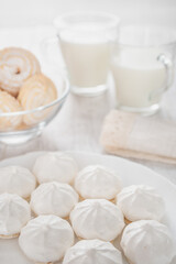 Obraz na płótnie Canvas White round marshmallows, two cups of milk, cookies in powdered sugar.