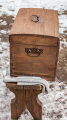 Wooden chest on a wooden bench amid a spring snow