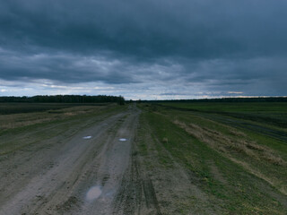 Fototapeta premium A dirt road among the fields in the evening. Autumn landscape.