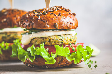 Vegan falafel burger with vegetables and sauce, dark background. Healthy  plant based food concept.