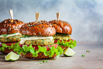 Vegan falafel burger with vegetables and sauce, dark background, copy space. Healthy  plant based...