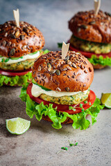 Vegan falafel burger with vegetables and sauce, dark background. Healthy  plant based food concept.